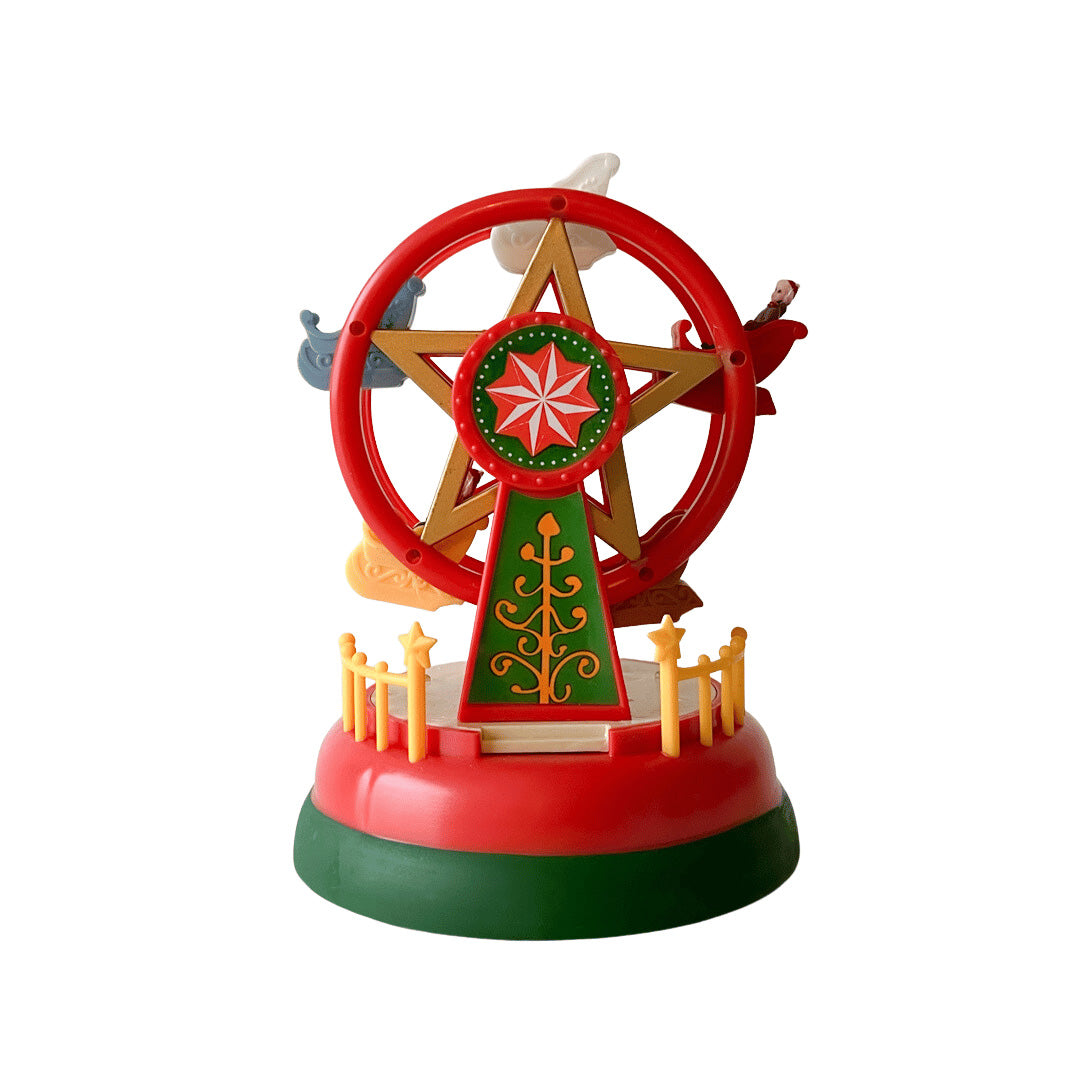Juledekorasjon formet som pariserhjul med rødt, grønt og gull, med små figurer i vognene.