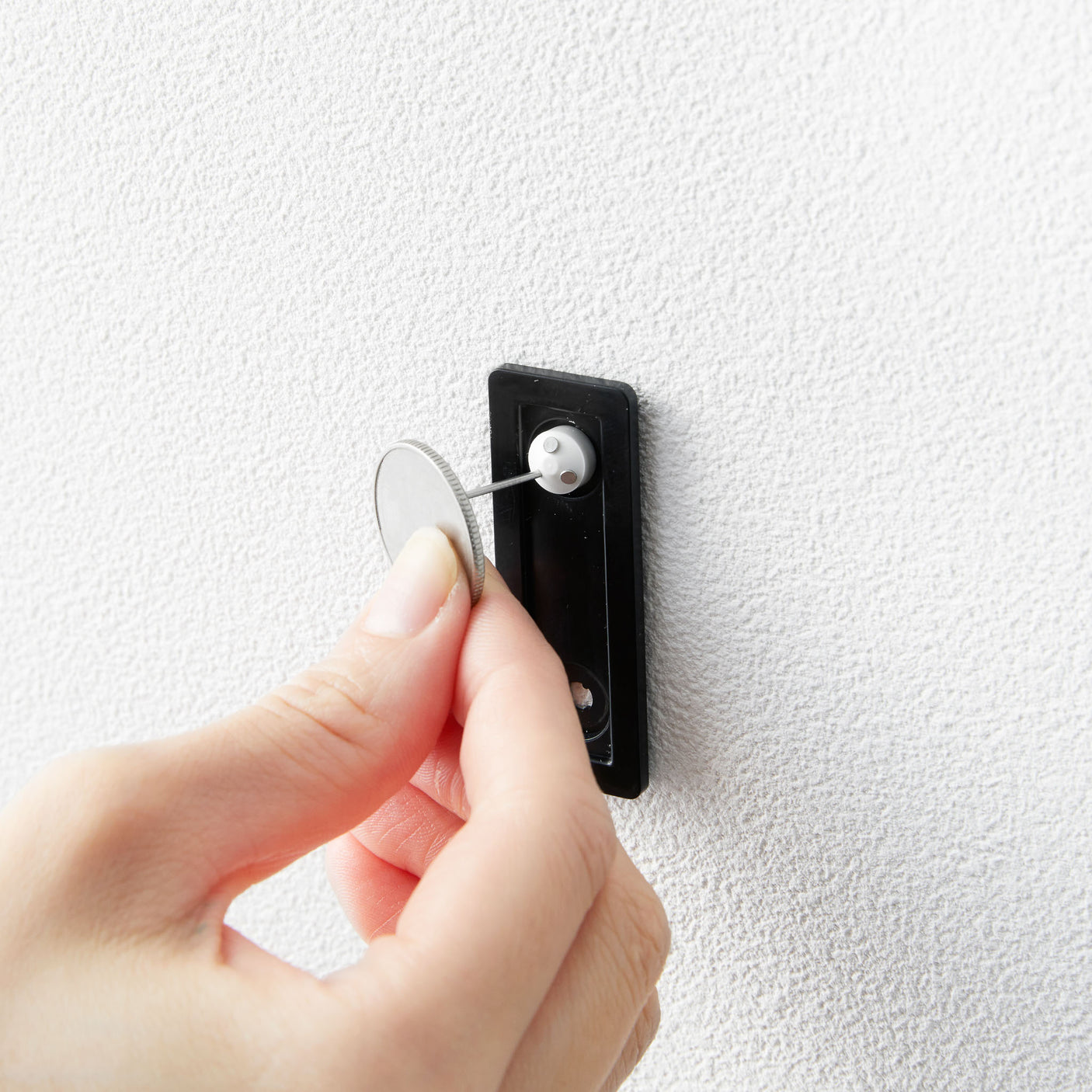 Minimalistisk veggboks i sort metall brukt til oppbevaring av småting.