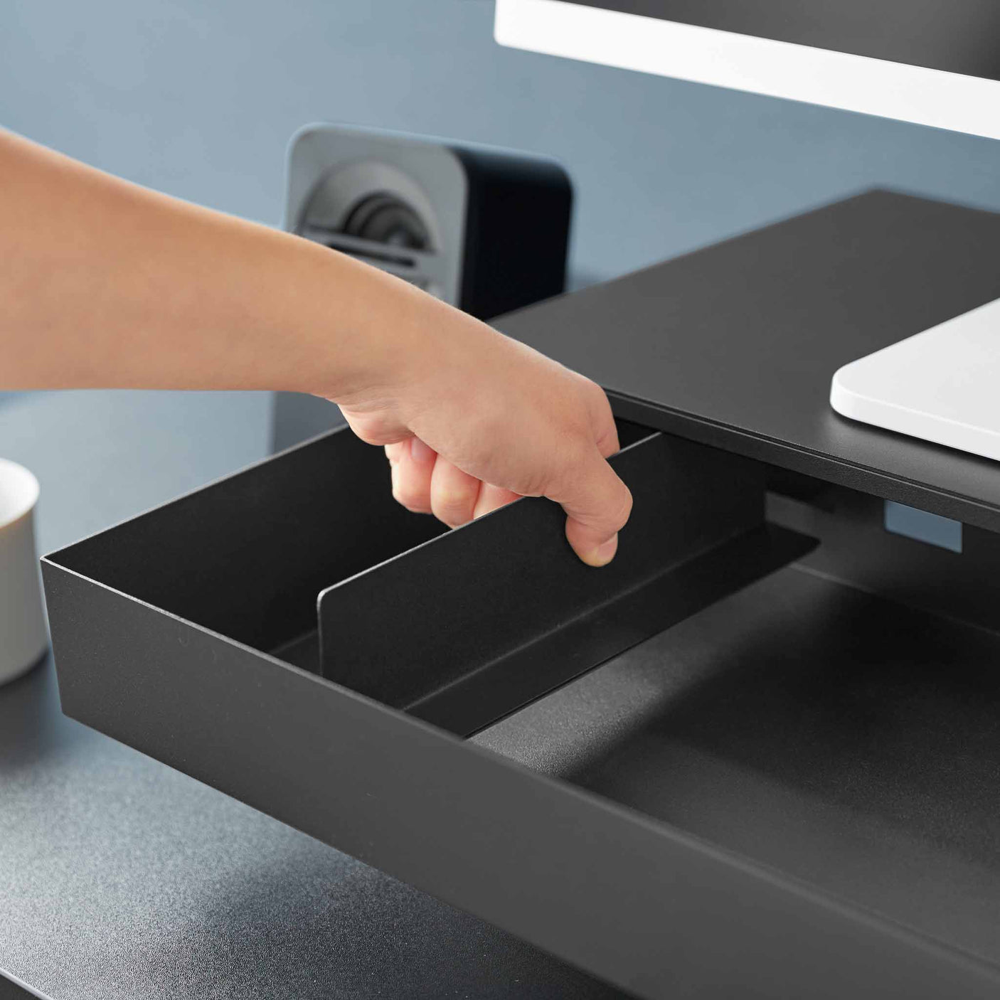 Praktisk sort skjermstativ med kabelutgang bak og ren bordflate