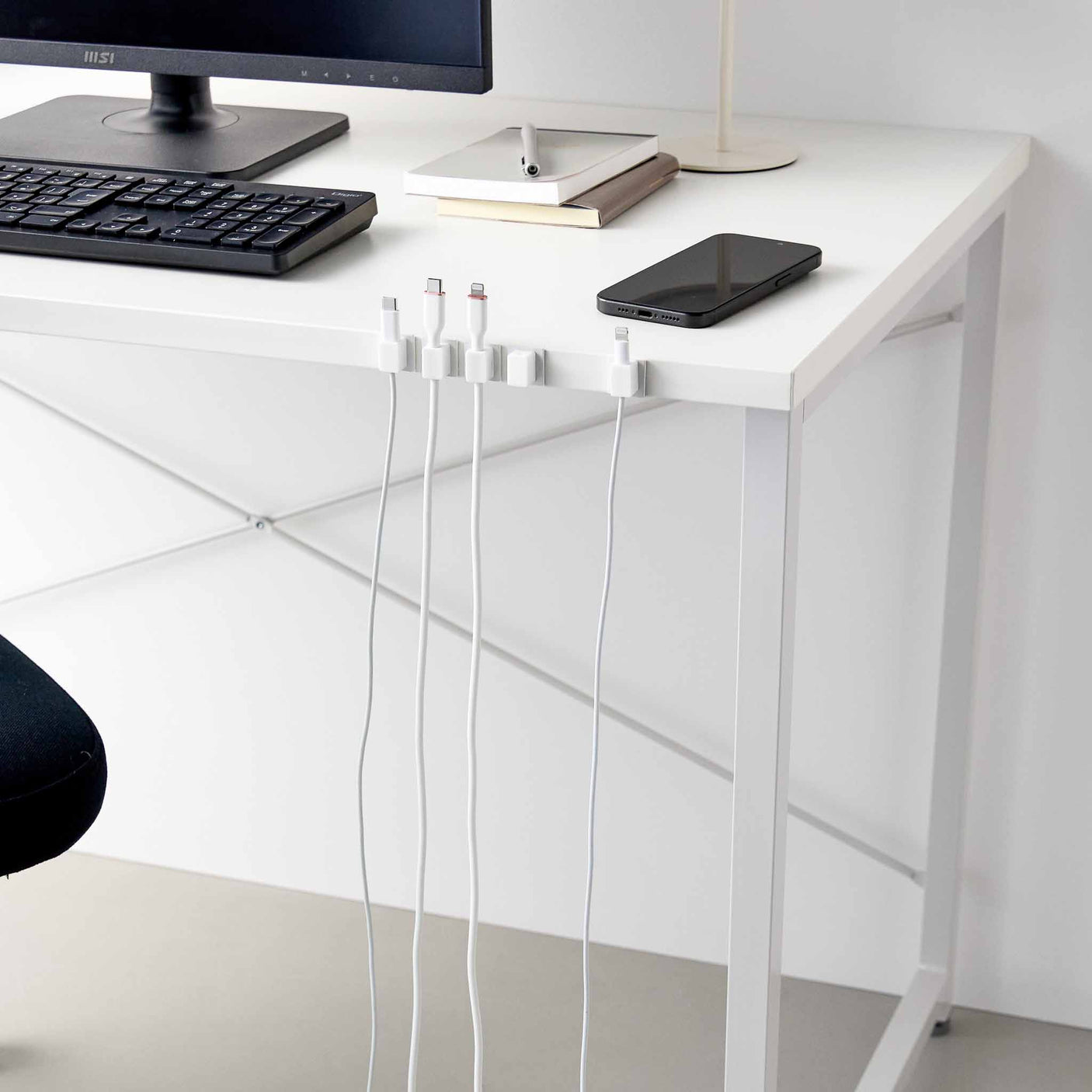 Kompakt kabelholder sett i hvit utførelse for organisering av ladekabler