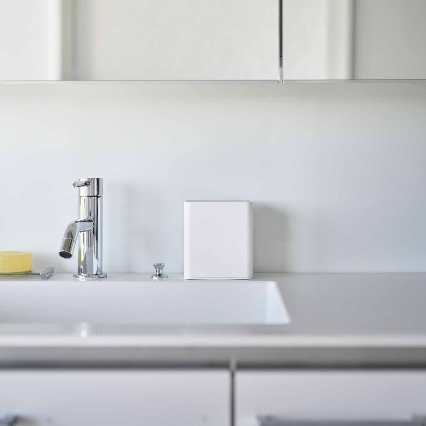 Hvit småoppbevaring med lokk og fire separate rom for organisering