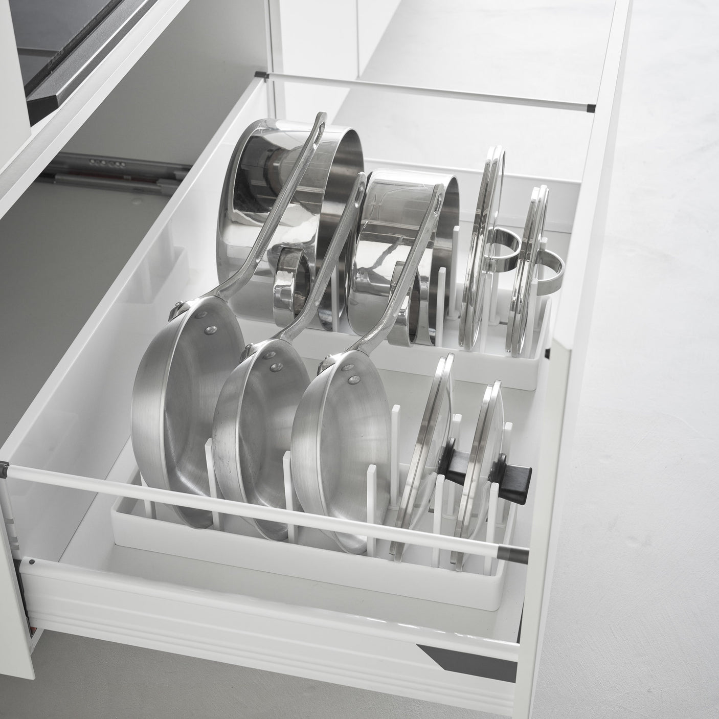 Hvit justerbar holder for gryter og lokk som holder utstyr ryddig og tilgjengelig.