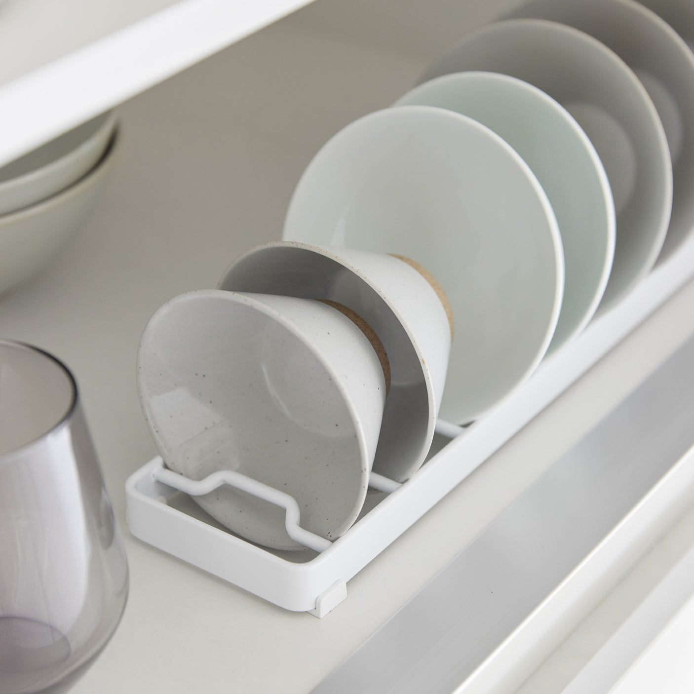 Kompakt hvitt stativ til skåler og kopper – praktisk oppbevaring i kjøkkenskap.