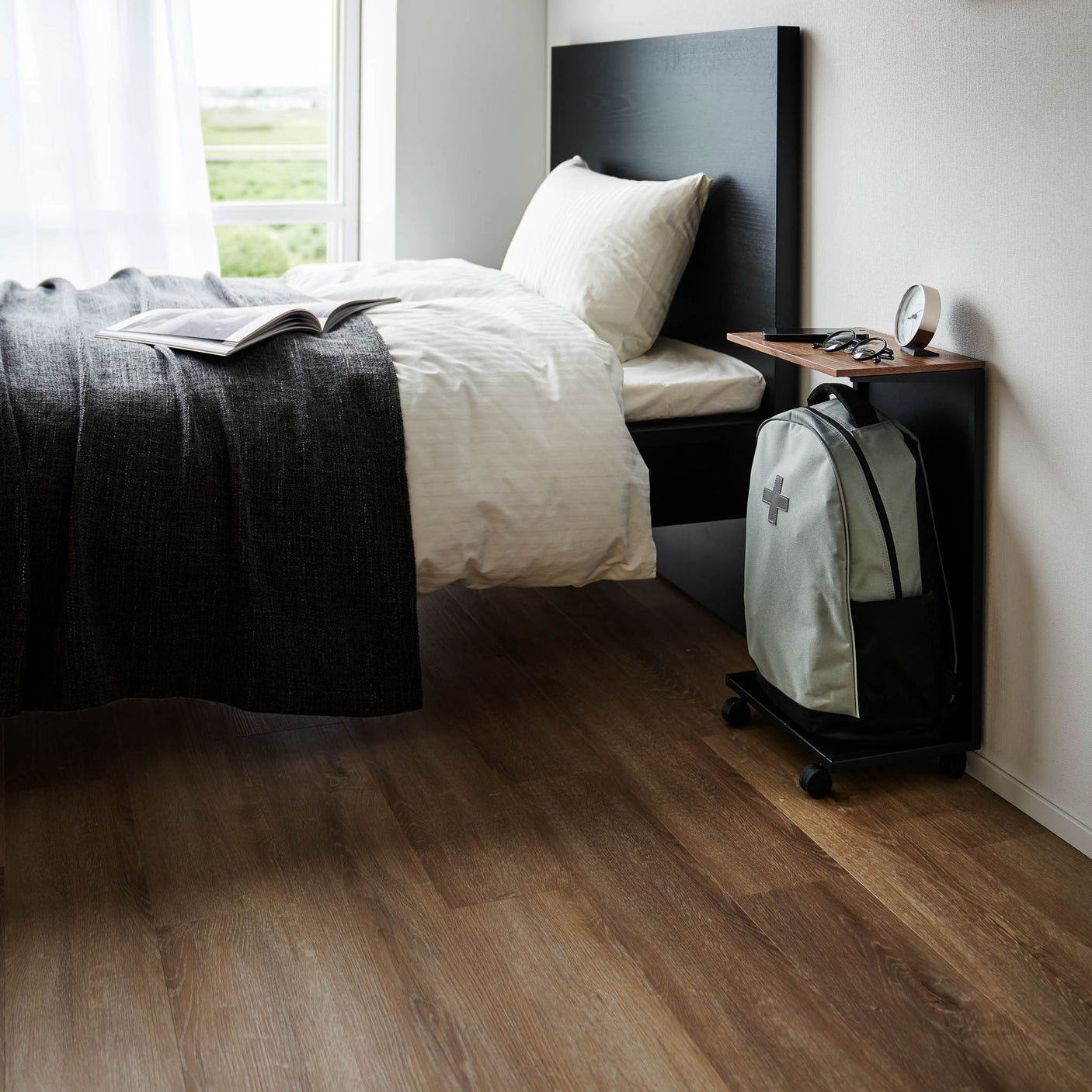 Sidebord med mørk ramme og lys treplate, brukt ved sofa i moderne stue.