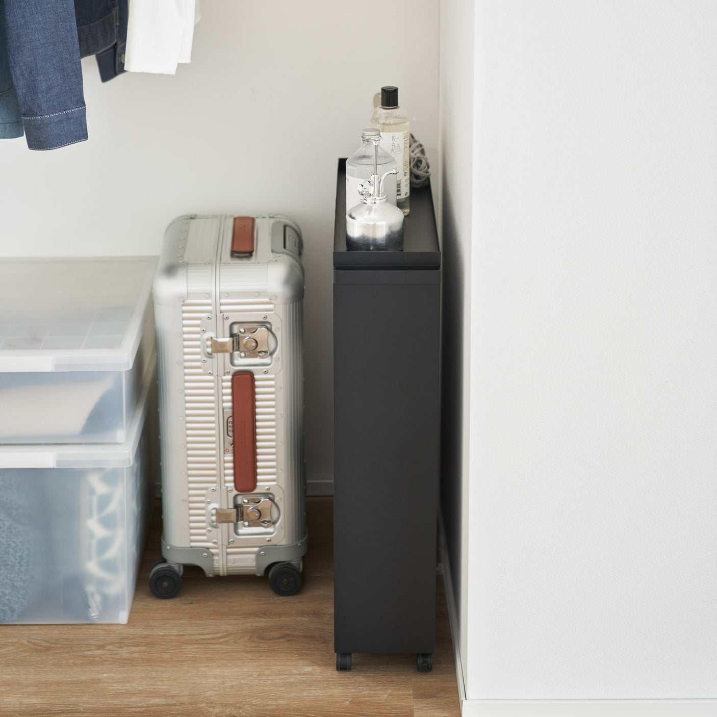 Sort oppbevaringsvogn for bøker og småting plassert mot blå vegg.