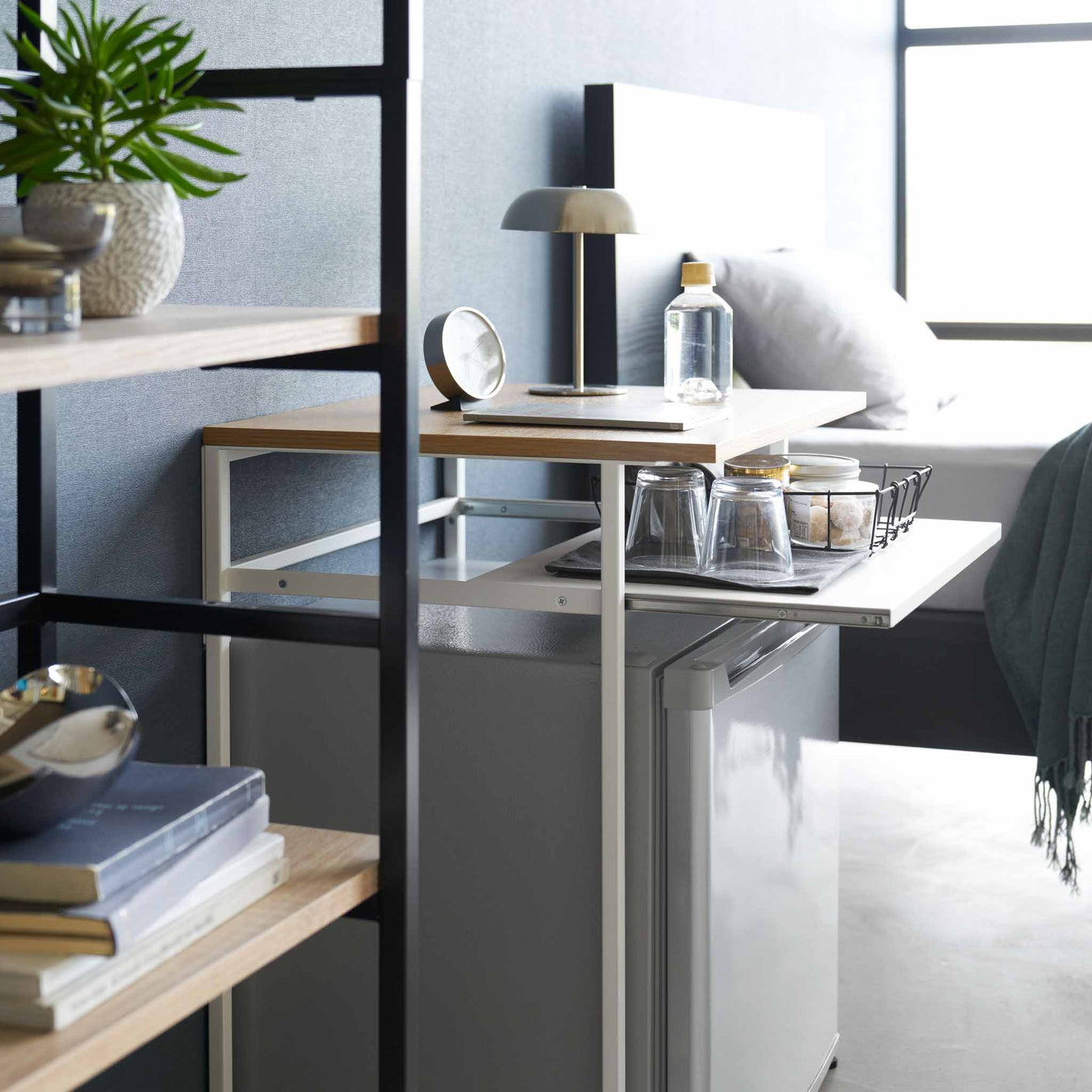 Detaljbilde av uttrekkbar hylle på sidebord med hvit stålramme