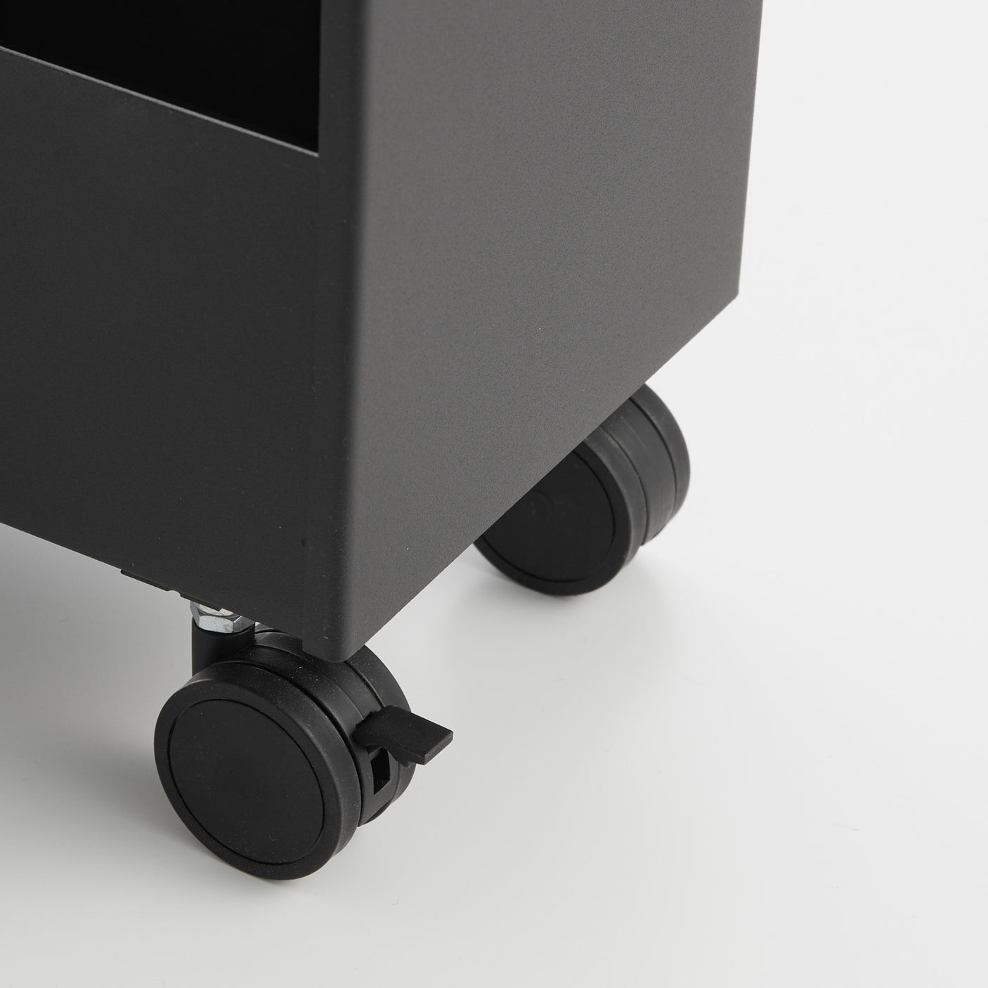 Svart oppbevaringsvogn plassert ved vaskemaskin og badekar.