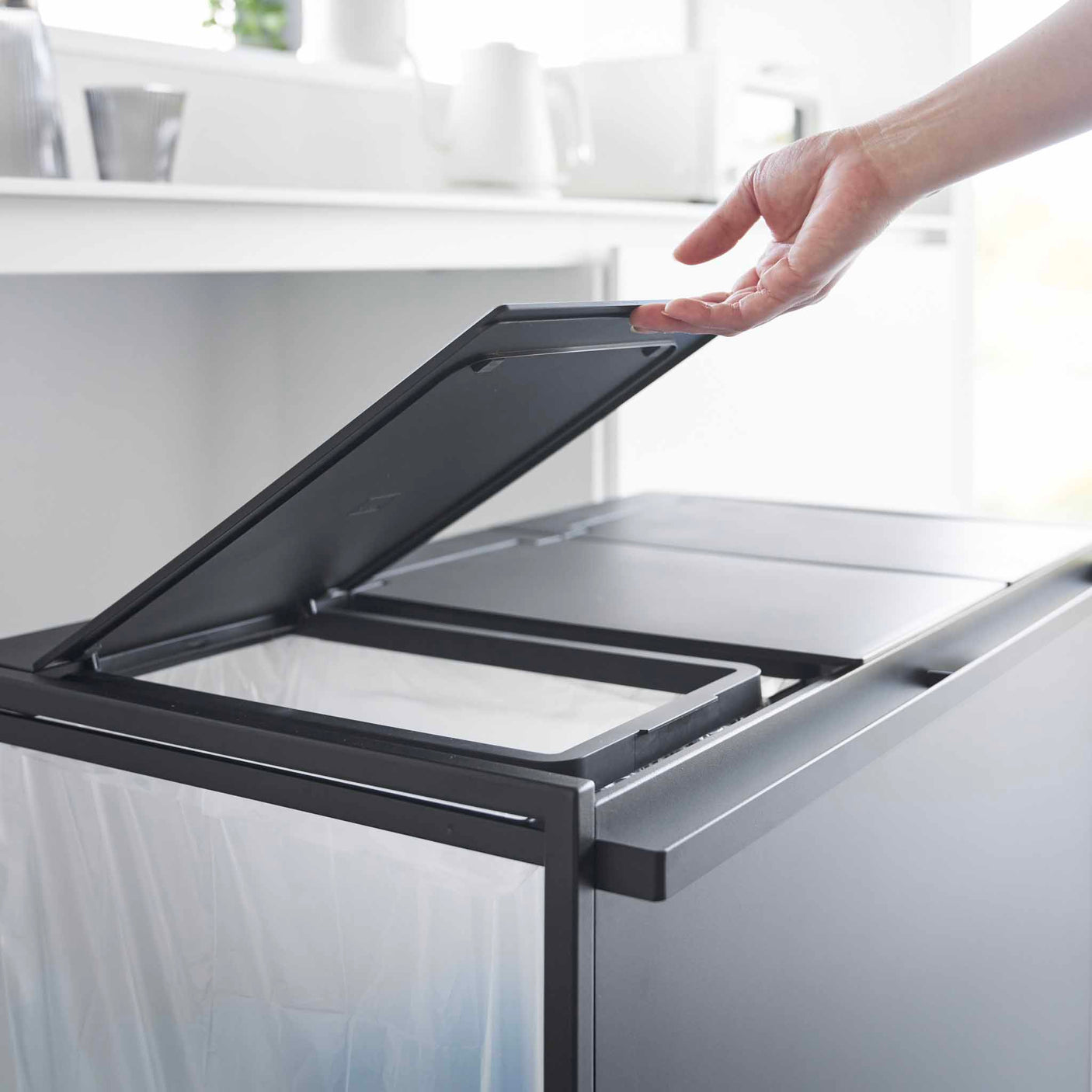 Lokk åpnes på kildesorteringsstativ med tre separate avfallsposer