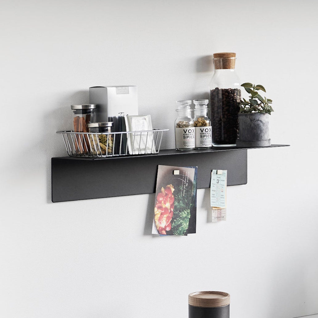 Magnetisk vegghylle i sort metall for oppbevaring og organisering.