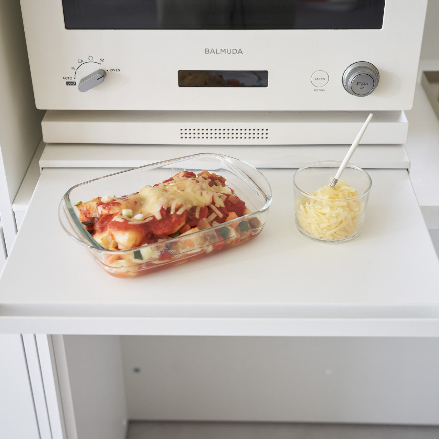 Uttrekkbar hylleplate med pizza og serveringsfat på kjøkken