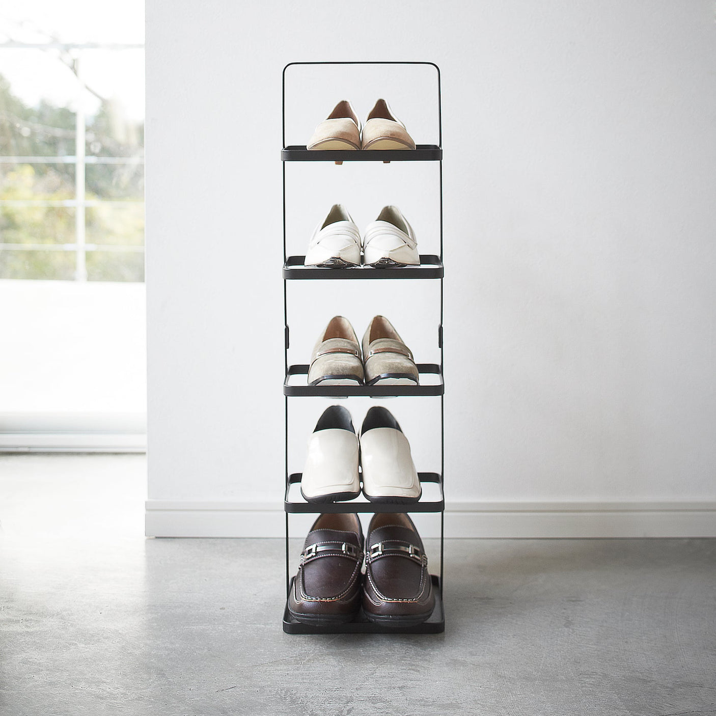 Nærbilde av skohyllens solide metallramme og minimalistiske design.