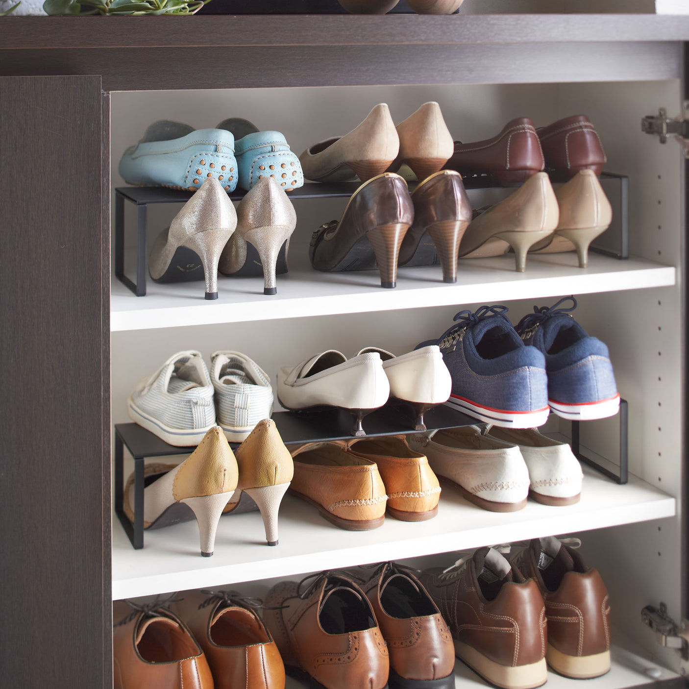 Sort skohylle i stål, justerbar i bredden og stabelbar for praktisk oppbevaring.