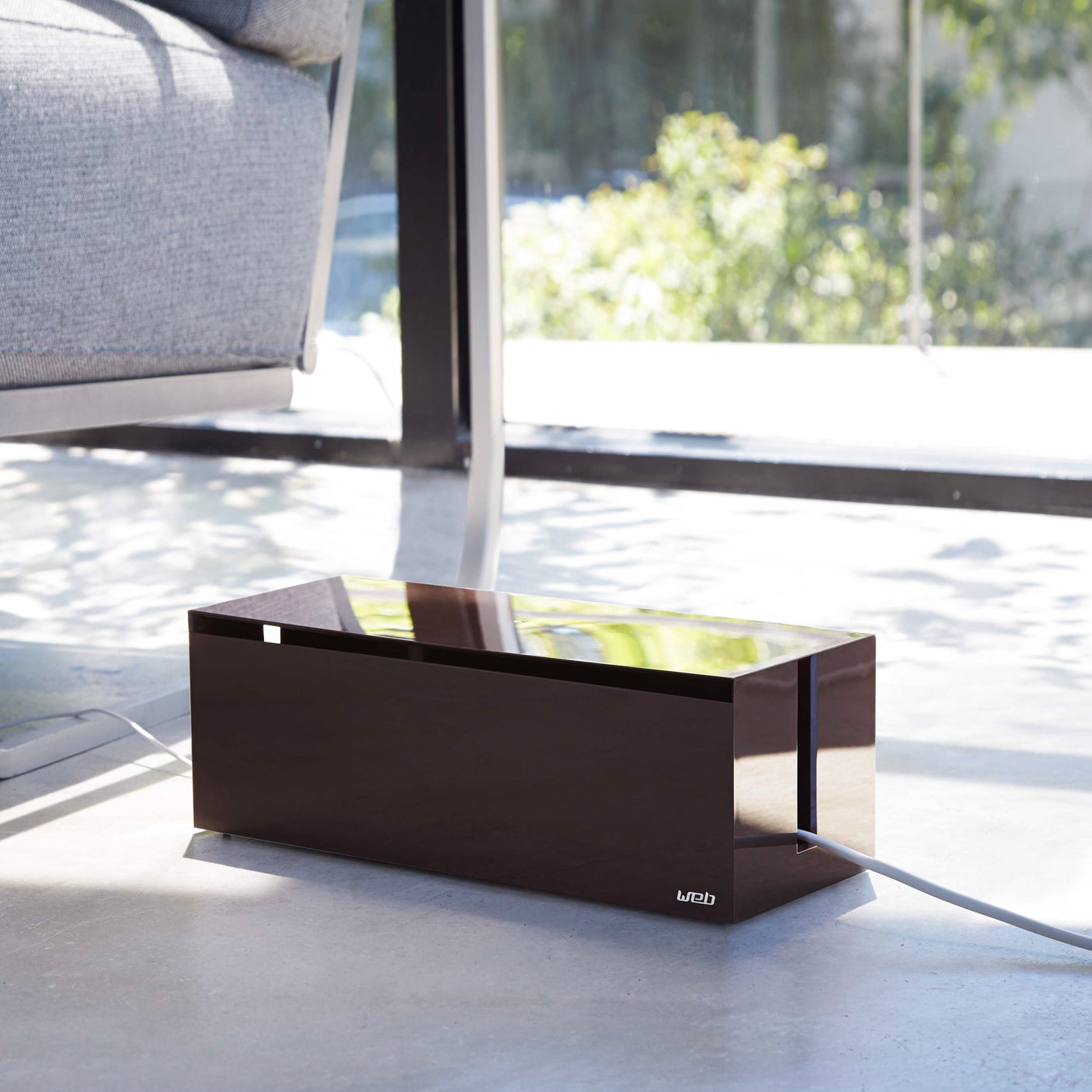 Brun kabelboks som skjuler skjøteledning og ladere.