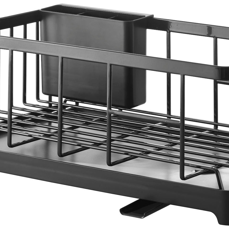 Kjøkkenbenk med sort oppvaskstativ fylt med blå tallerkener, bestikk og glass.