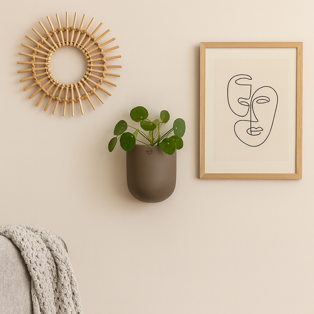 Vegghengt keramikkpotte med plante, stylet med ramme og dekorativ rund veggdekor.