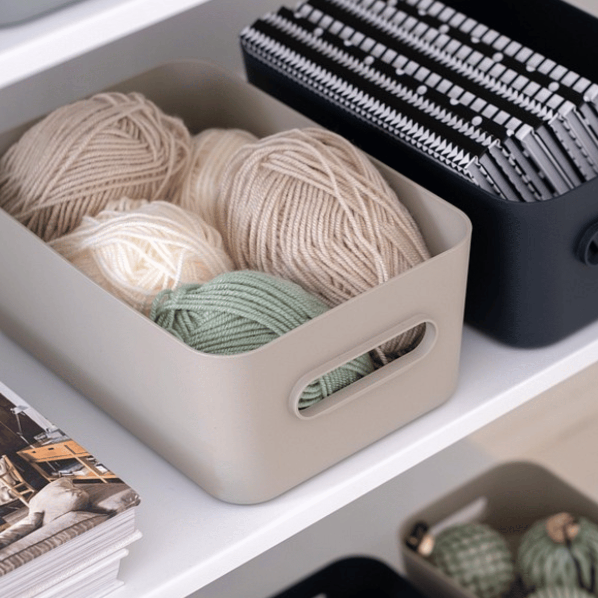 Beige SmartStore Comfort oppbevaringskurv med garnnøster til strikking, ved siden av en Comfort kurv