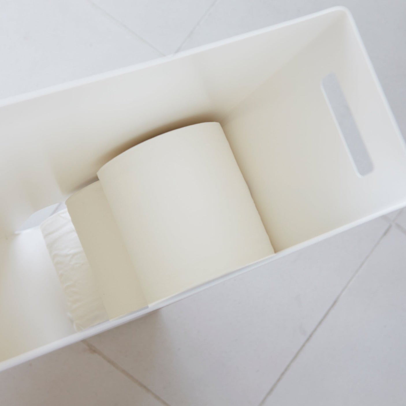 Elegant toalettpapirbeholder med praktisk åpning i bunnen.