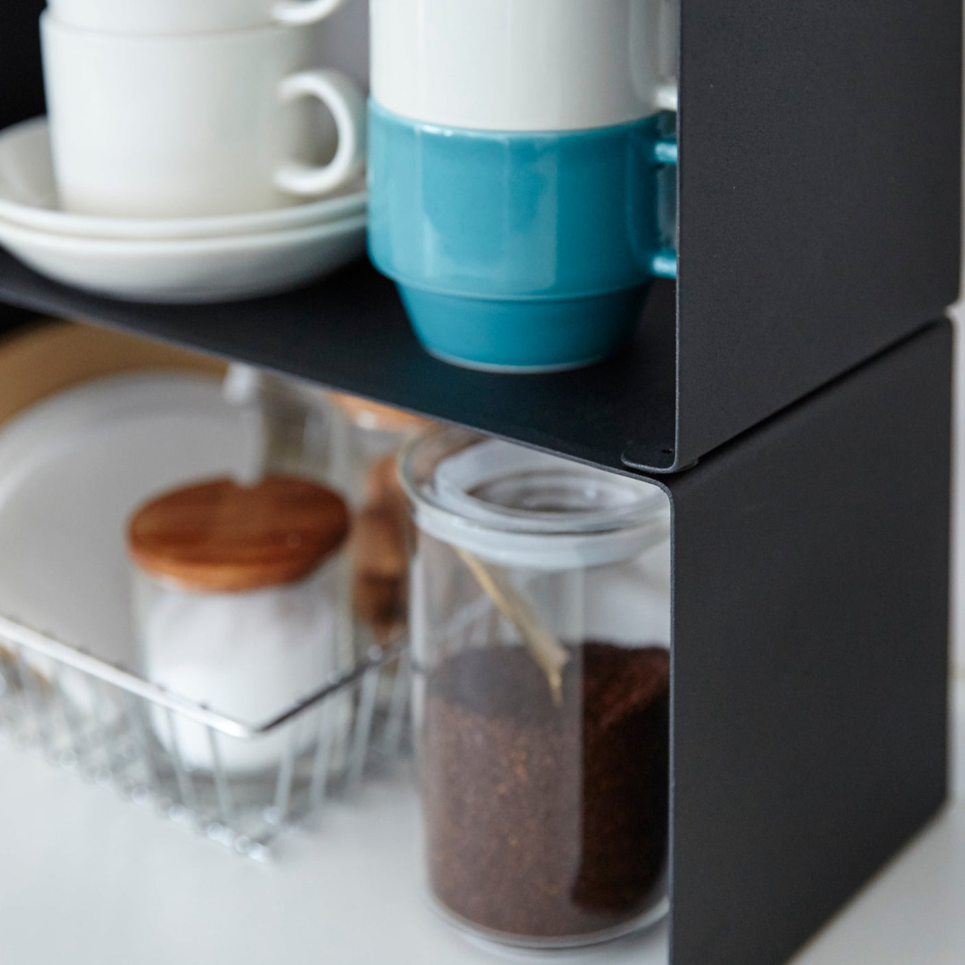 Smal sort hylle perfekt for krydderglass, redskaper og håndklær.