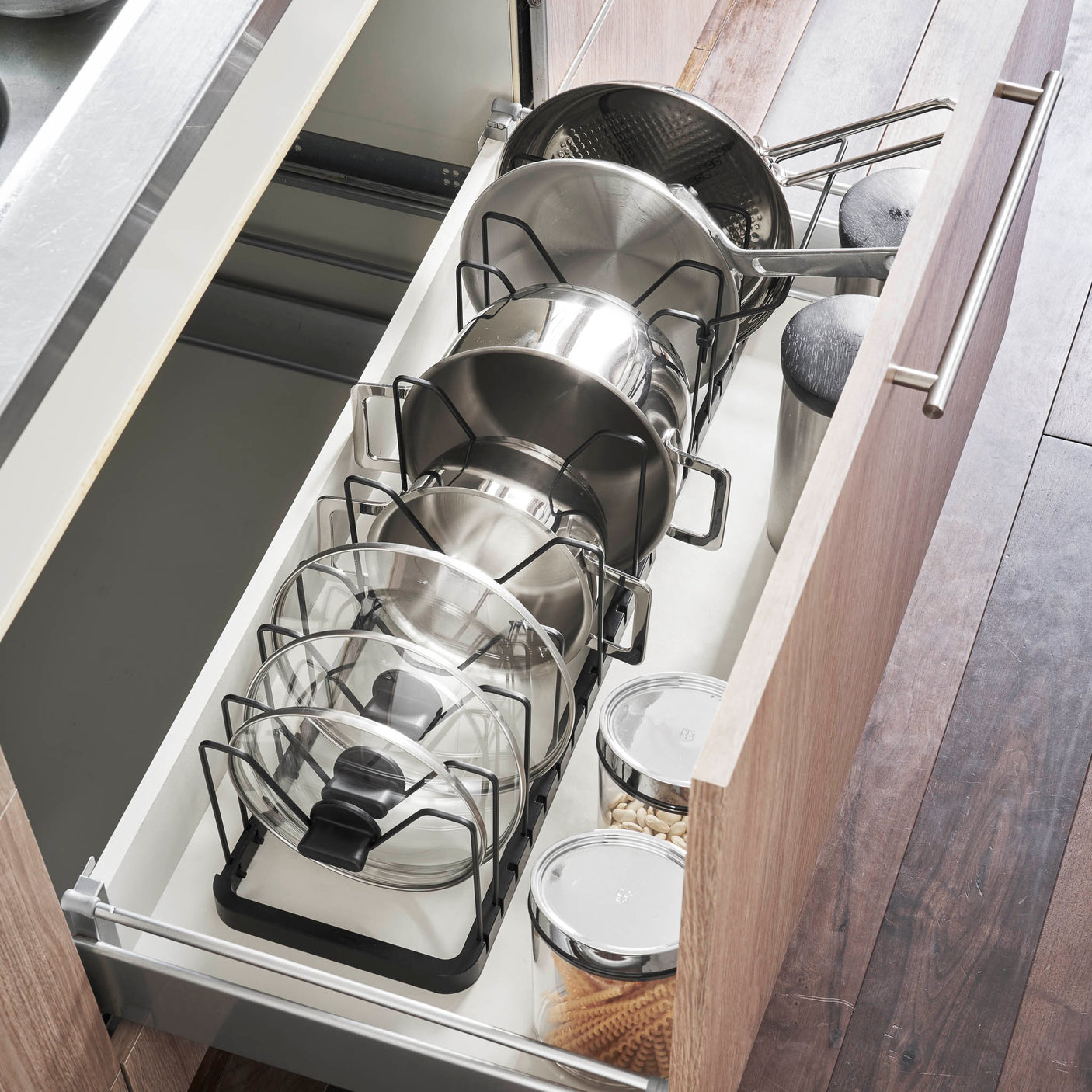 Justerbar lokkholder i sort metall til kjøkkenorganisering.