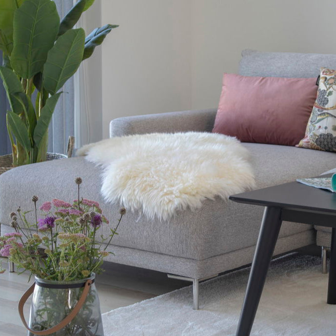 Mykt hvitt lammeskinn fra House Nordic stylet på lyse tregulv.