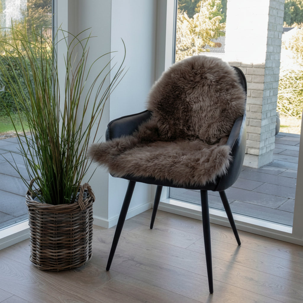 Elegant grå lammeskinn brukt på moderne stol for myk komfort.