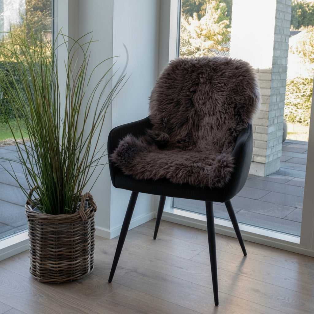 House Nordic lammeskinn i varm brunfarge brukt som gulvteppe ved peisen.