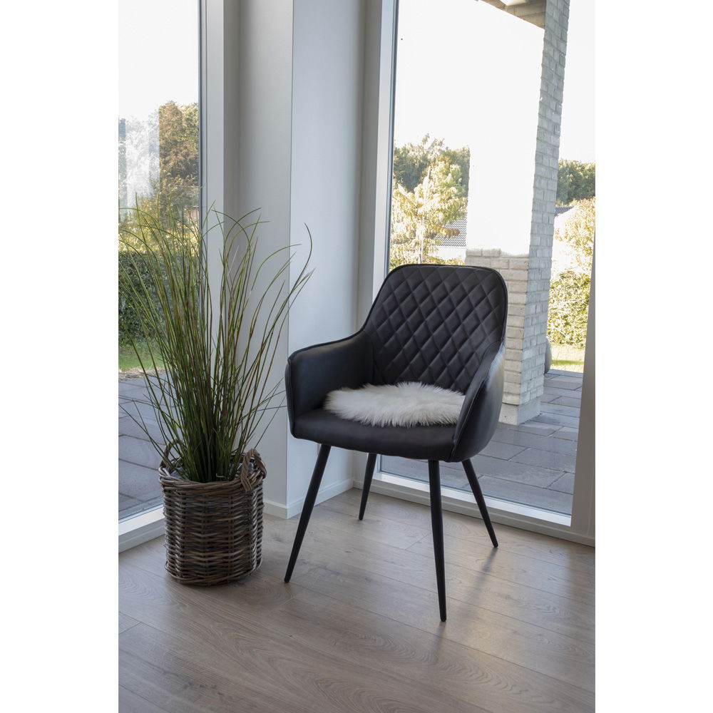 Hvitt sitteunderlag i kunstig saueskinn på stol i moderne stue