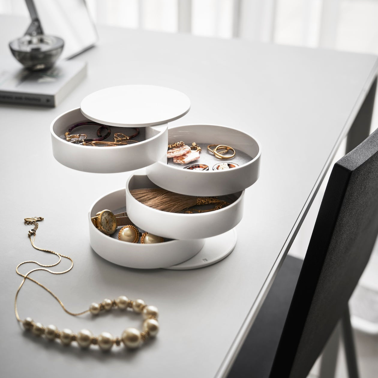 Roterbar smykkeboks i hvitt med fire lag for praktisk oppbevaring.