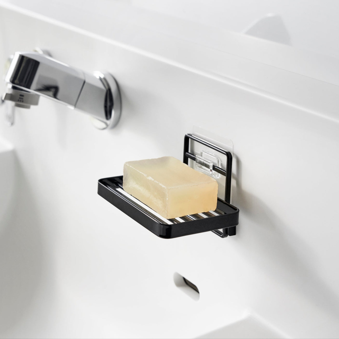Sort veggmontert såpeholder med selvklebende feste.