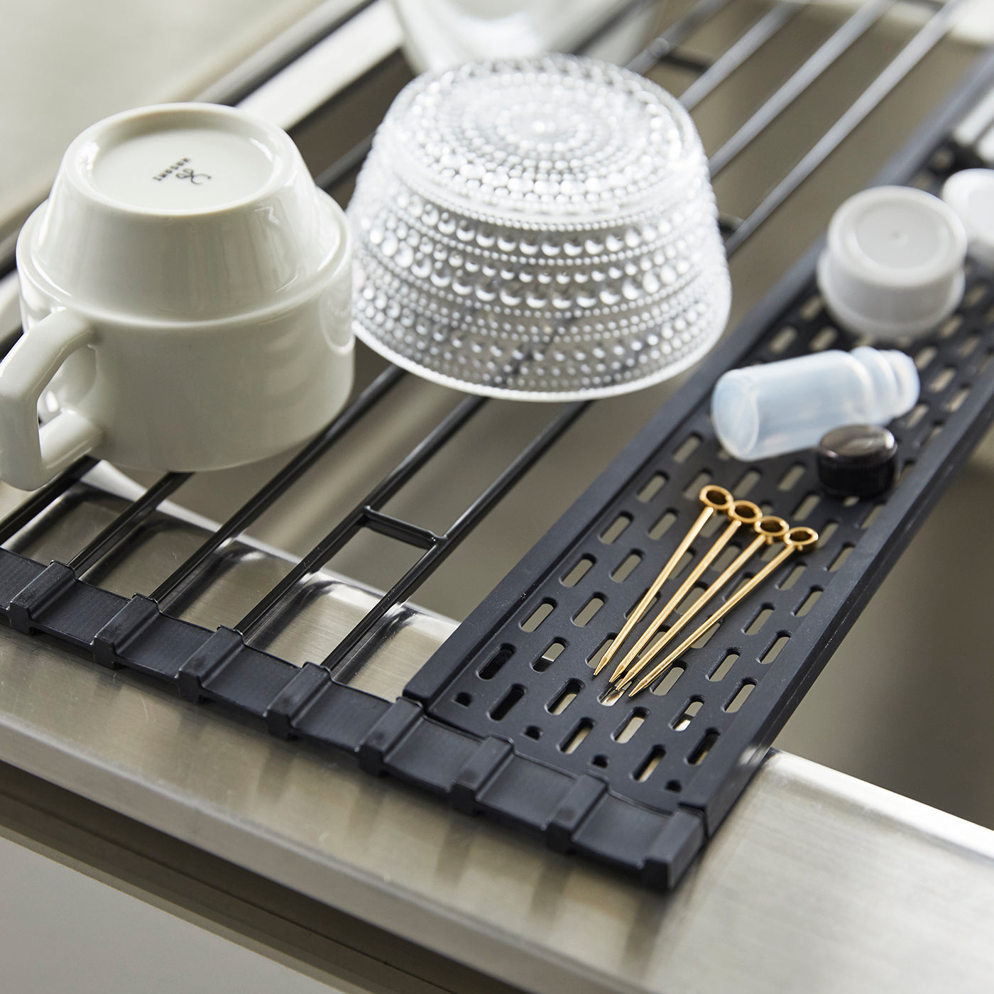 Sammenleggbar sort oppvaskrist for kjøkkenbenk.