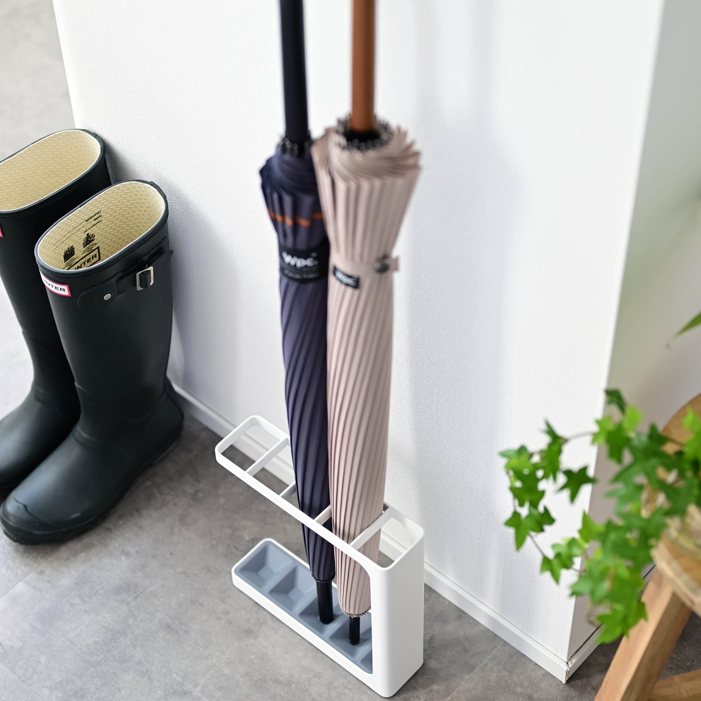 Paraplystativ lite plassert ved ytterdør – praktisk oppbevaring i entré.