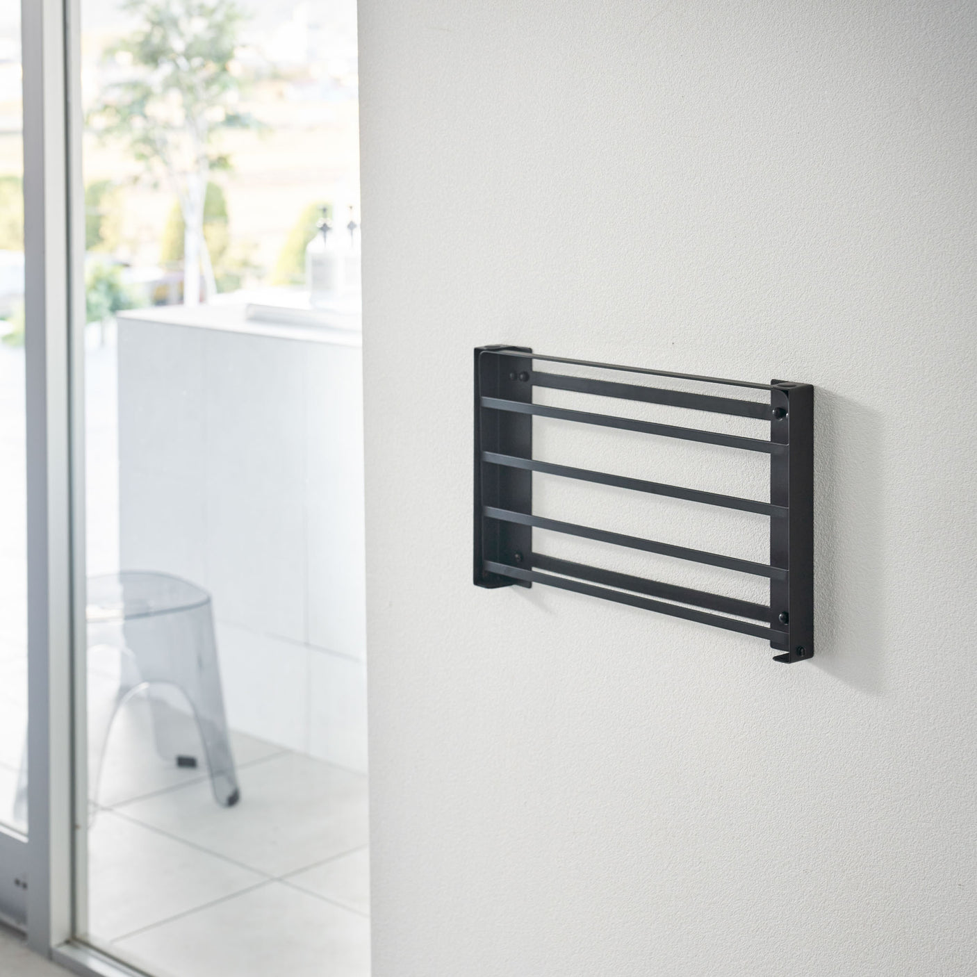 Person folder ut sort metallhylle på vaskerom.