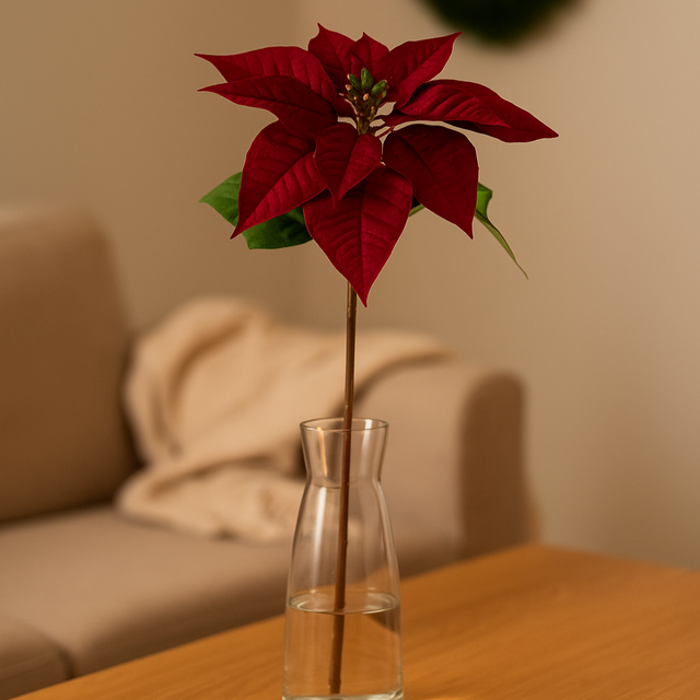 Kunstig julestjerne på 70 cm stilk i vase på stuebord, med dyp røde blader og grønt midtparti – elegant juledekorasjon.