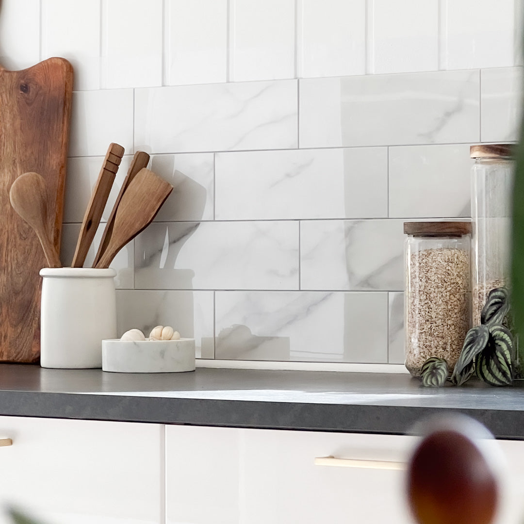 Stilrent kjøkken med selvklebende marmorfliser i lyse, elegante toner.