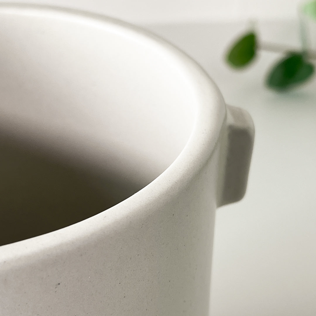 Nærbilde av Justine potte i kremfarget steingods med matt overflate.