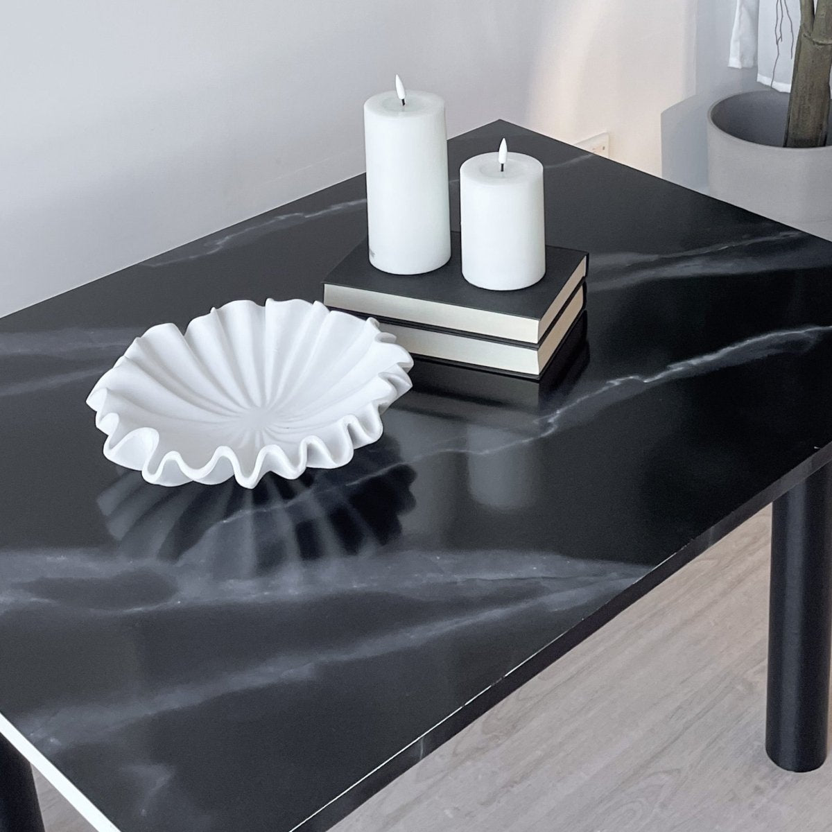 Nærbilde av selvklebende kontaktplast i sort marmordesign med hvite årer.