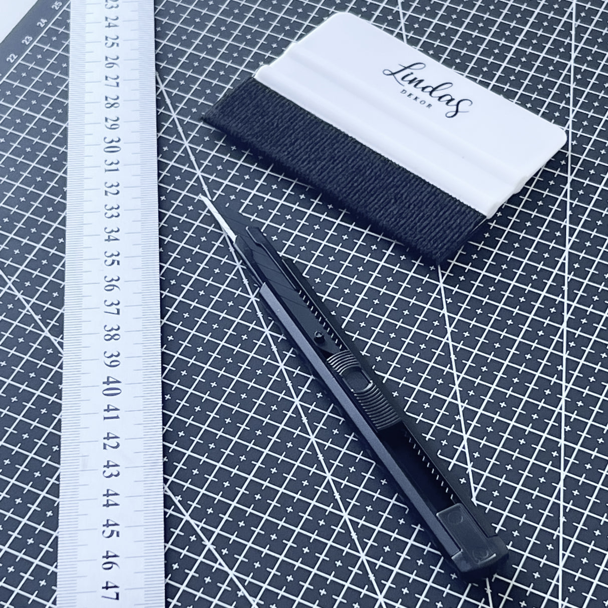 Skjærematte med stållinjal, tapetkniv og foliesletter for nøyaktig og enkel skjæring.