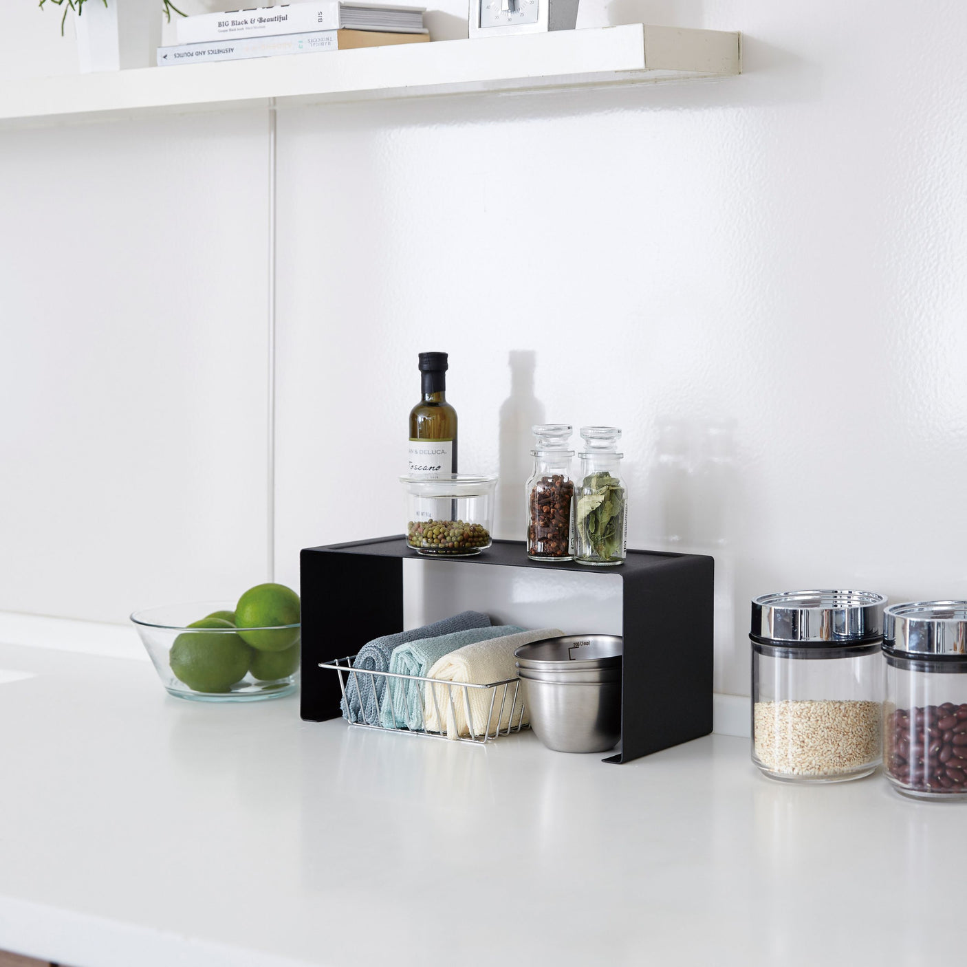 Sort stablehylle for organisering av kjøkkenutstyr og krydder.