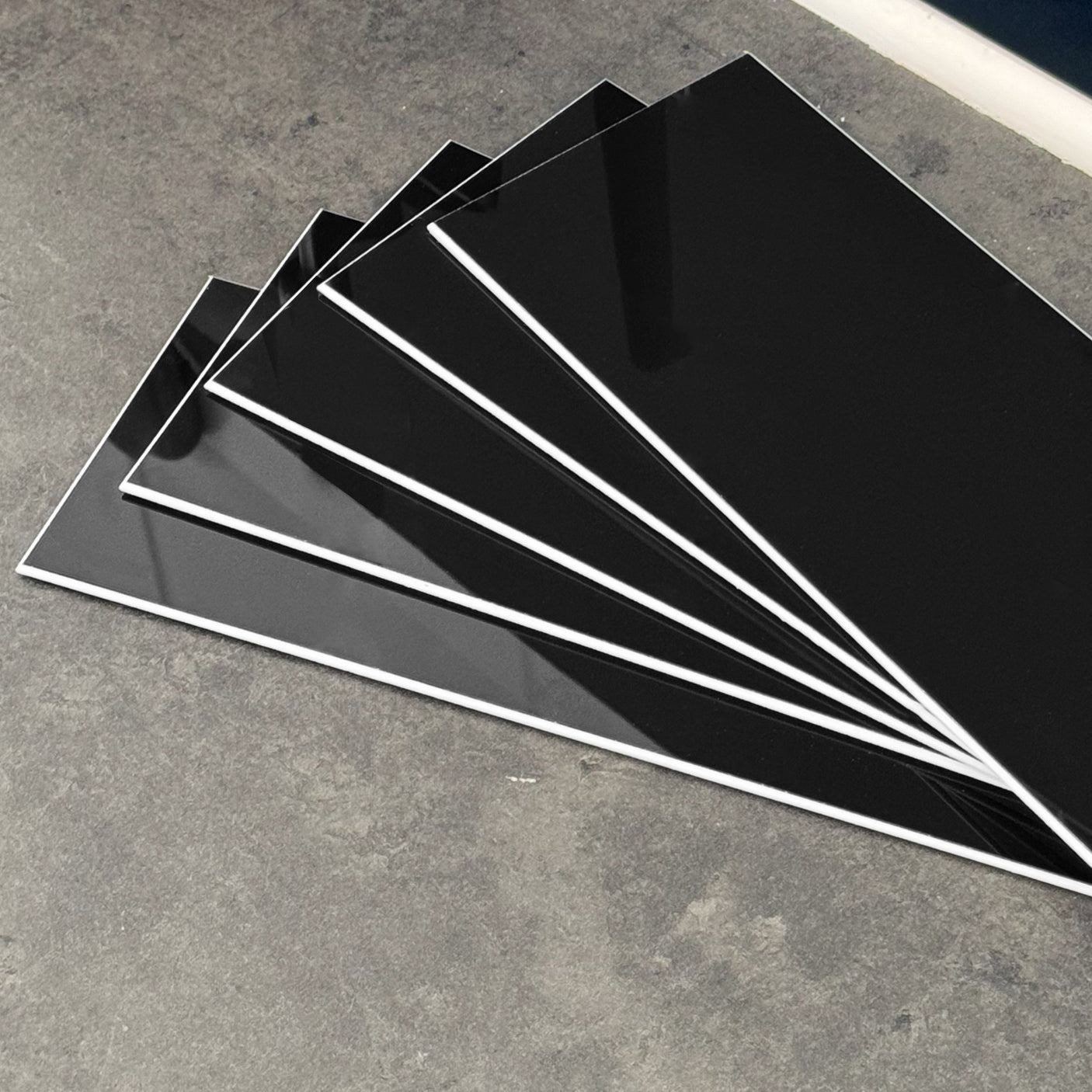 Sorte veggfliser brukt som backsplash på kjøkken med lys benkeplate