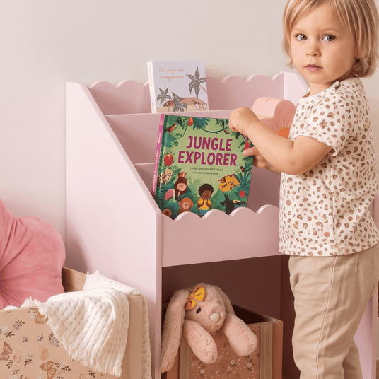 Barn tar bok fra rosa bokhylle Antea i barnehøyde på barnerom