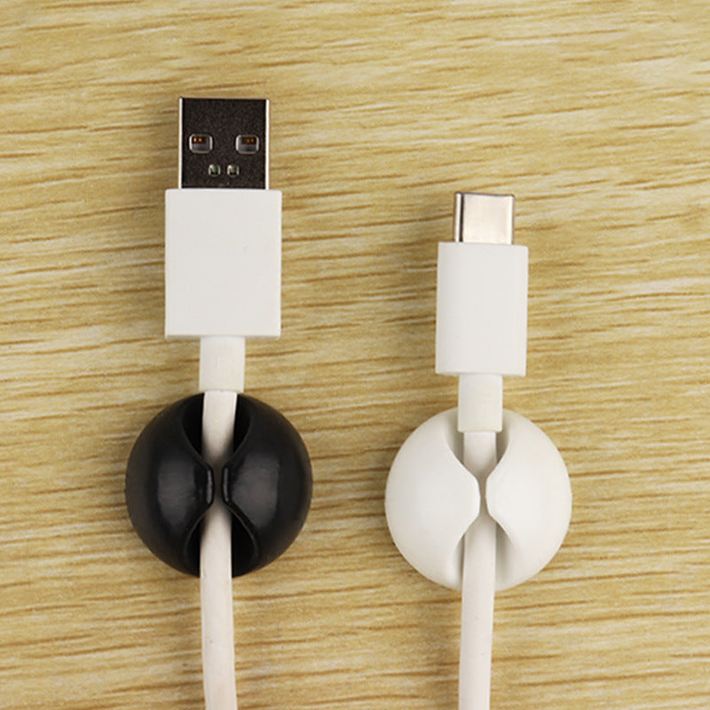 Minimalistisk kabelholder i plast eller gummi, brukt for å organisere en enkelt kabel.