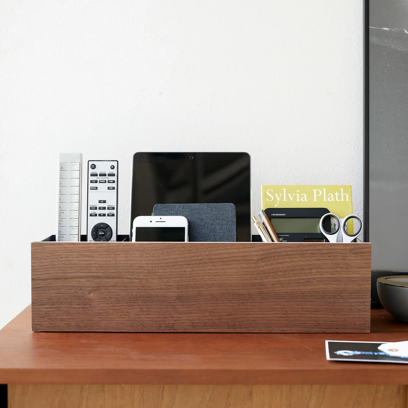 Svart oppbevaringsløsning med trepanel for ryddig bord og benk