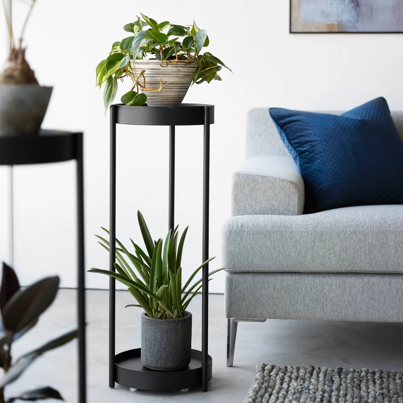 Sort stativ til planter med to runde flater og minimalistisk uttrykk