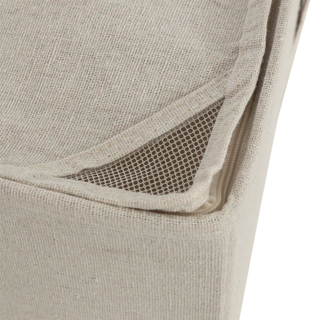 Nærbilde av ventilasjonsåpning i hjørnet på beige oppbevaringsboks, med netting som bidrar til luftsirkulasjon.
