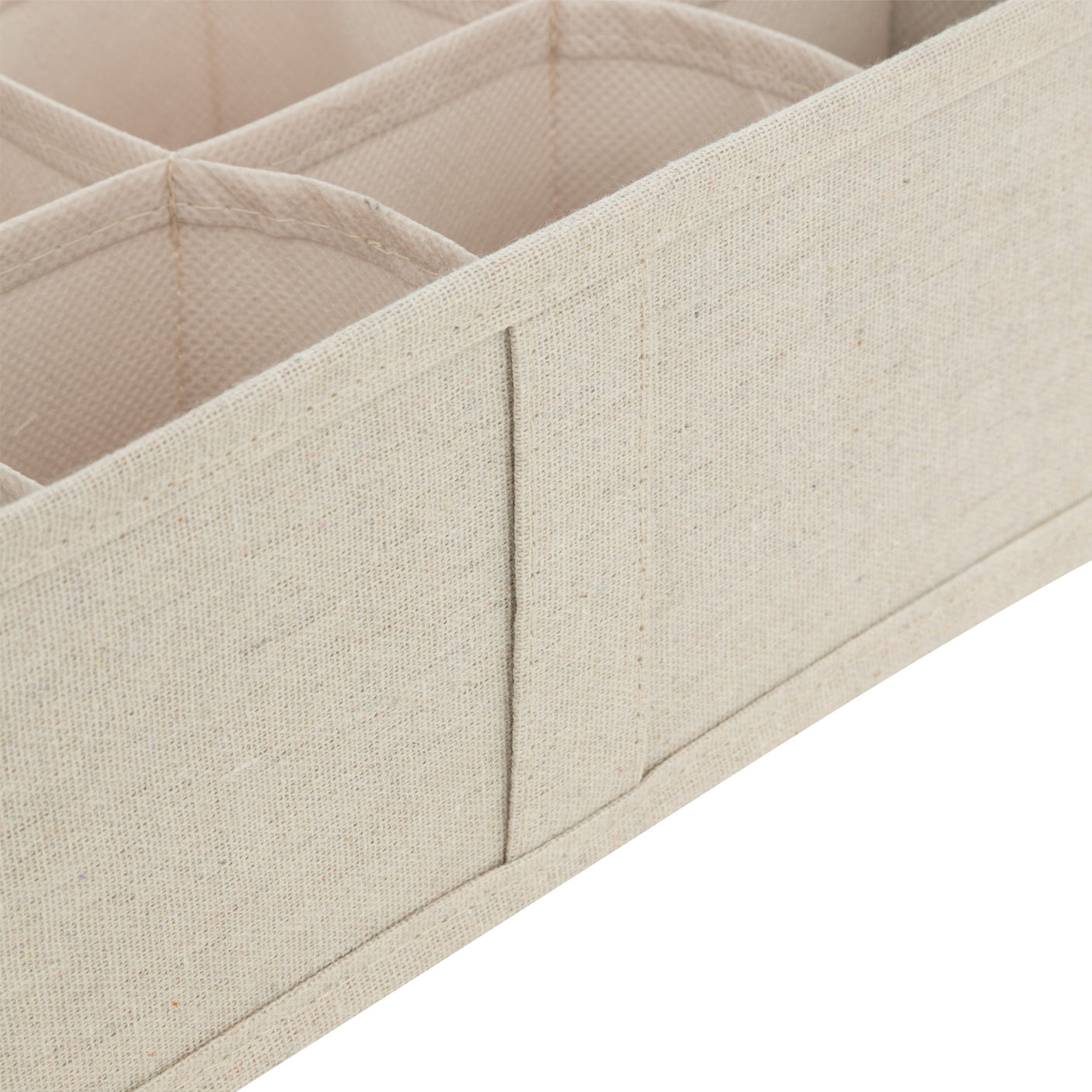Nærbilde av beige skuffeorganiser med stofftrukne skillevegger og rominndeling.