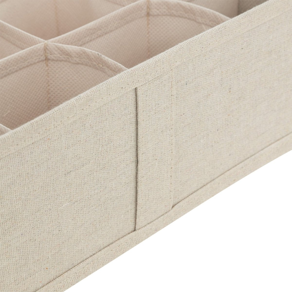 Nærbilde av beige skuffeorganiser med stofftrukne skillevegger og rominndeling.