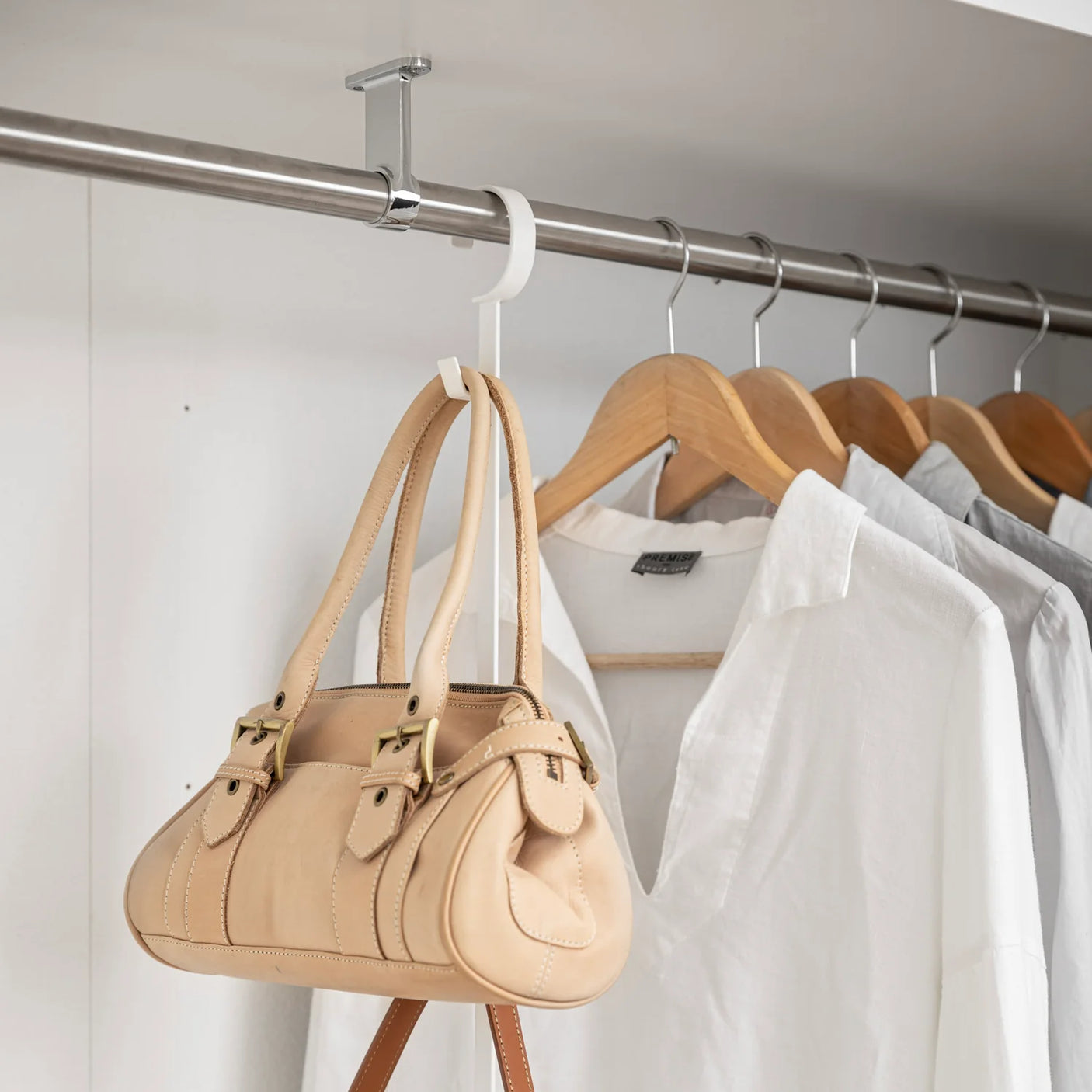 OppbevaringslĂžsning til garderobe med to stenger og kroker i hvitt metall nĂŠrbilde