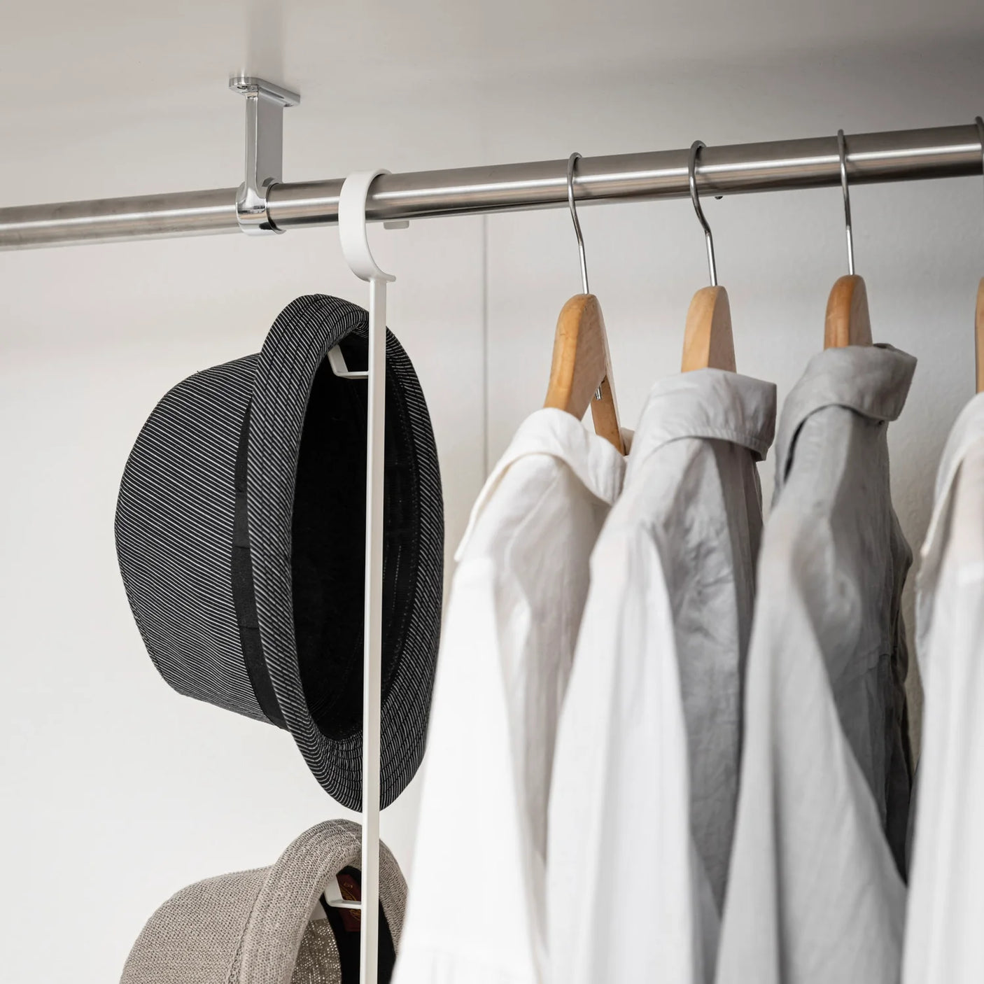 Hvit garderobestang med hĂžydejustering for bedre organisering i skap