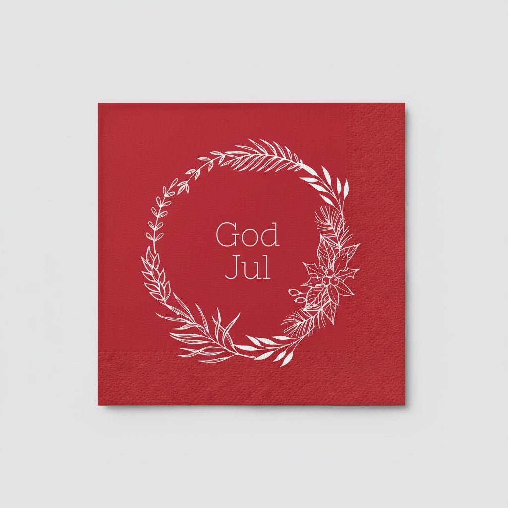 Julstämning med serviett med vit krans och «God Jul»-text på det däckta bordet