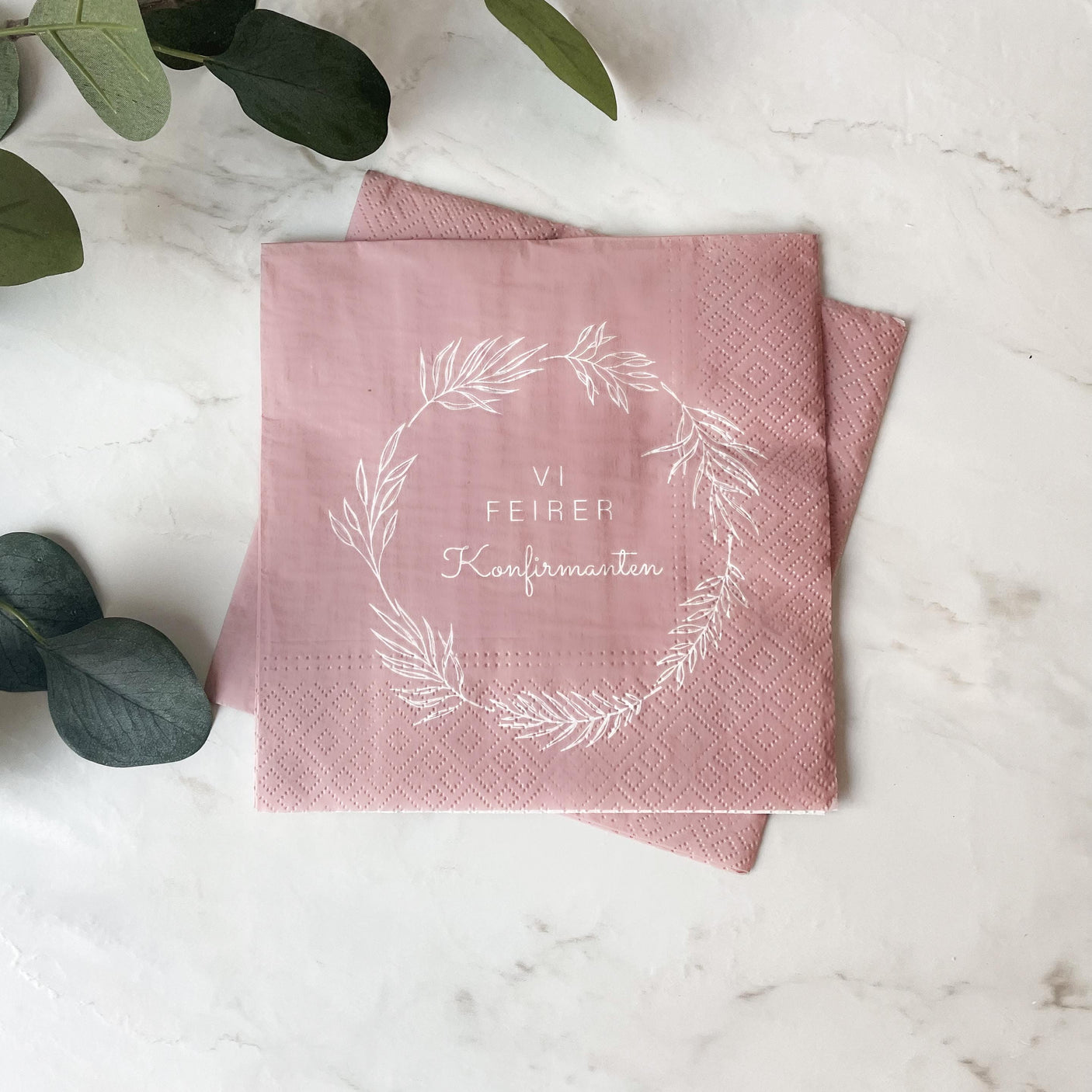 Hyperrealistisk nærbilde av konfirmasjonsserviett i rosa på tallerken med naturlig lys.